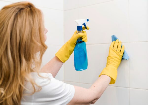 Mujer/Hombre realizando una desinfección profunda en el baño de su hogar.